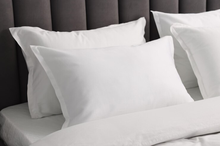 Photo many soft pillows on bed at home closeup