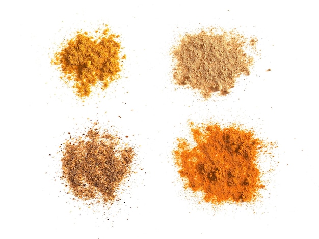 Many spices including Ginger Curry Turmeric and Chili Pepper over white