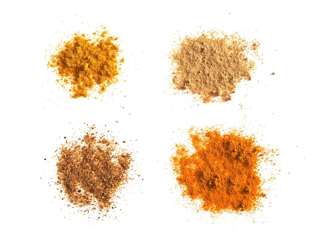 Many spices including Ginger Curry Turmeric and Chili Pepper over white