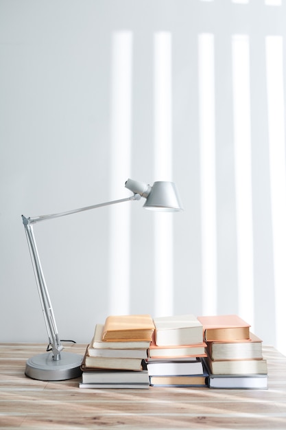 Many students books on big table with modern lamp