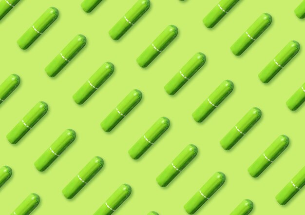 Photo many tampons on light green background flat lay