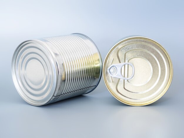 Photo many tin cans of gold and silver color, isolated on a gray background, top view, copy space.