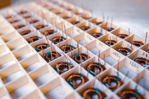 Many twisted copper coils lie in the compartments for the further production of electronic equipment. Factory concept for the production of medical equipment