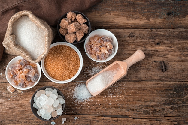 Many types of sugar on a wooden background. Top view with copy space.