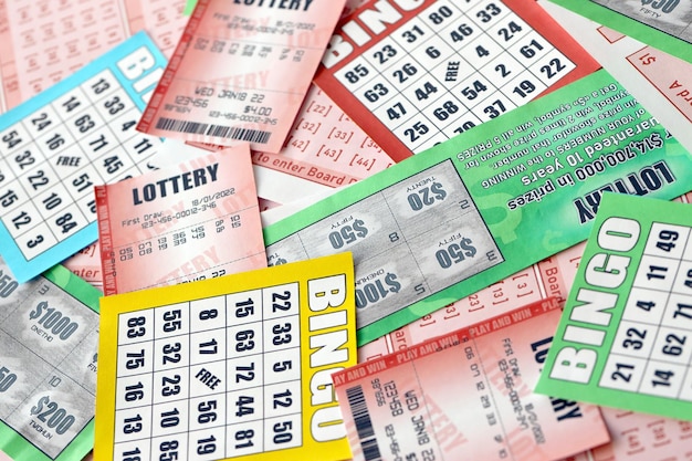 Many used lottery tickets bills with numbers and bingo playing\
boards in big pile gambling and lottery paper stuff