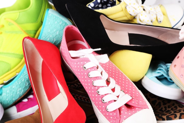 Many various female shoes closeup background