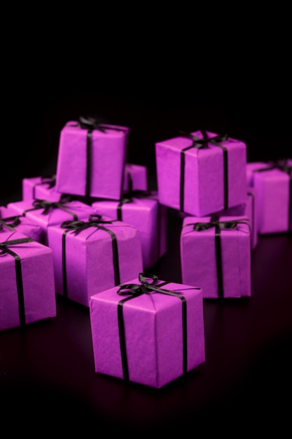 Many violet gift boxes on black background