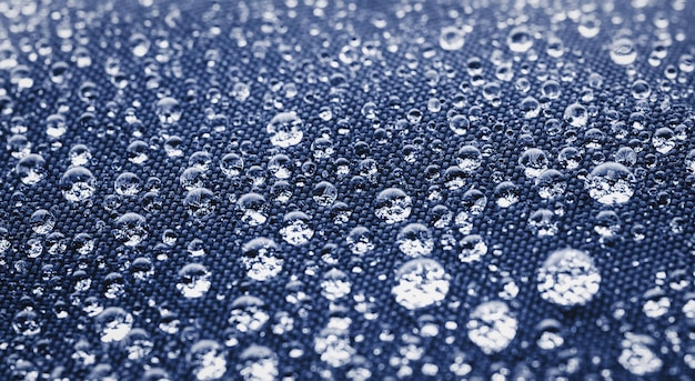 Фото Многие капли воды на темно-синей водонепроницаемой ткани