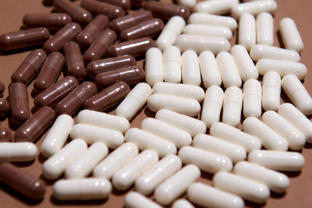 Many white and brown capsule pills on a colorful background. supplements and medicines that are good for your health