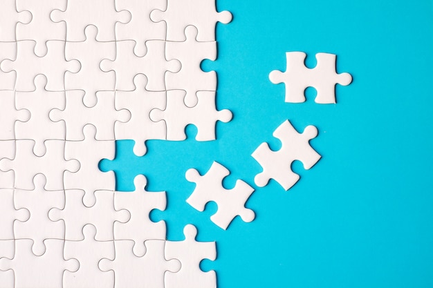 Photo many white jigsaw puzzle on blue background - idea solution concept.