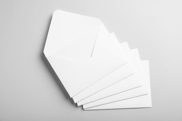 many white paper envelopes on light grey background flat lay