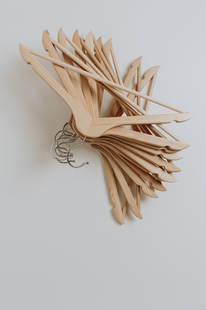 Many wooden hangers for clothes pattern on white