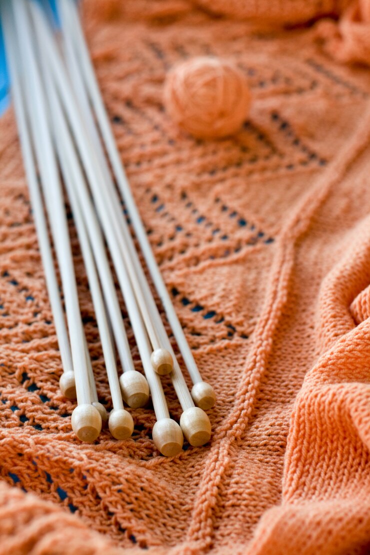 Photo many wooden spokes lie on an orange knitted plaid
