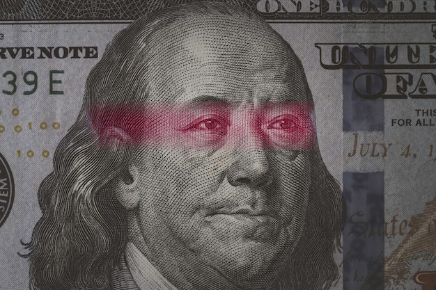 Mao Tse Tung eye from Yuan banknote insert on Benjamin Franklin face on USD dollar banknote for symbol of economic tariffs trade war and tax barrier between United States of America and China