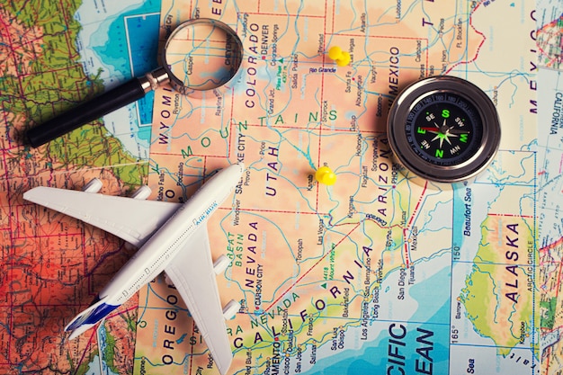 Photo the map, airplane and stuff on a wooden table