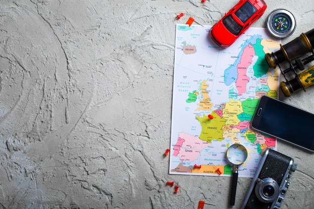 Photo the map, airplane, and traveling stuff on a wooden table