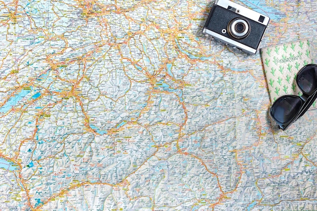 Foto mappa delle strade con occhiali da sole passaporto con fotocamera vintage vista dall'alto il concetto di viaggio spazio di copia piatto