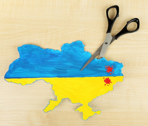 Map of Ukraine with blood and scissors isolated on white concept of war in the country