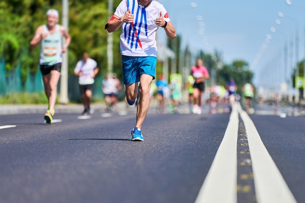 都市道路のマラソンランナー。ランニング競技。屋外での全力疾走。健康的なライフスタイル、フィットネススポーツイベント。