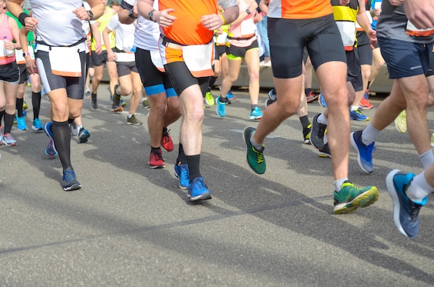 マラソンランニングレース、ロードレース、スポーツ競争、フィットネス、健康的なライフスタイルのコンセプトに多くのランナーの足