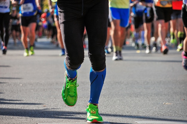 Maratona di corsa, piedi di molti corridori su strada, competizione sportiva, fitness e concetto di stile di vita sano
