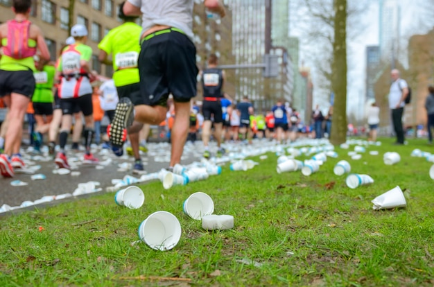 다과 포인트, 스포츠, 피트 니스 및 건강 한 라이프 스타일 개념 근처도 마라톤 달리기 경주, 주자 발 및 플라스틱 물 컵