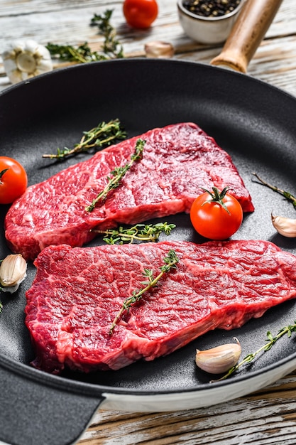 Marble beef Denver steak in a pan with herbs