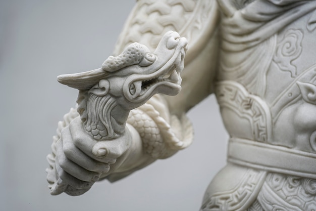 Photo marble dragon statue in the hands of a warrior in a buddhist temple in the city of danang, vietnam