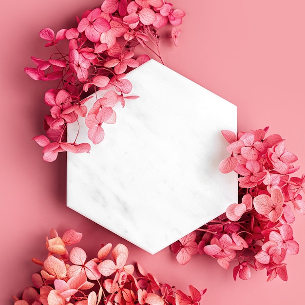 Marble  hexagon on pink background with flowers. Stylish background for presentation.