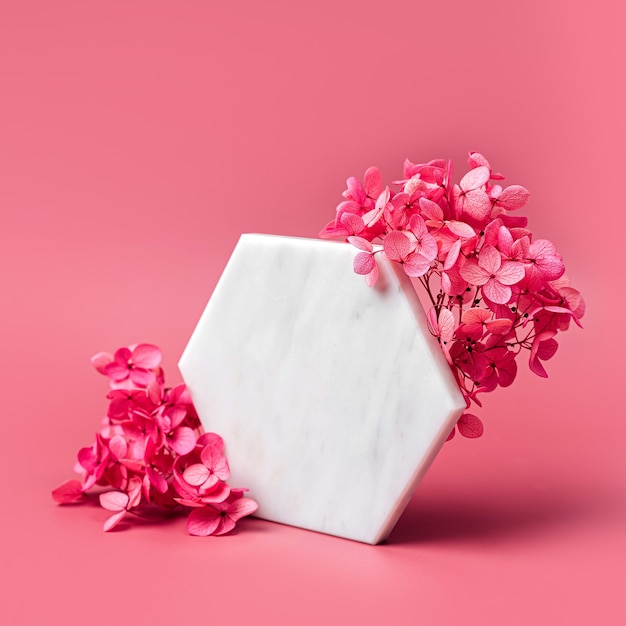 Marble  hexagon on pink background with flowers. Stylish background for presentation.