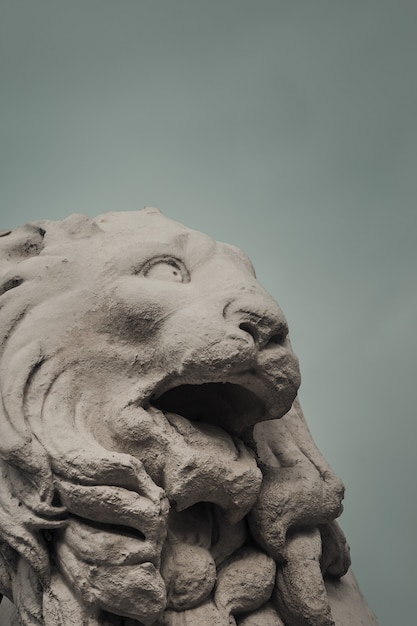 Marble lion head against a cloudy sky