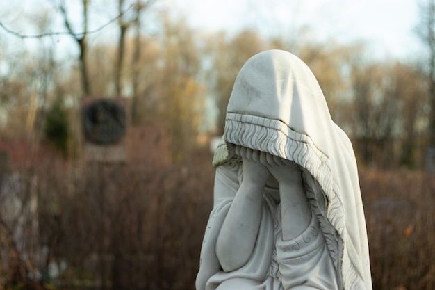 Marble sculpture of a grieving woman in a cemetery Concept of loss of a loved one and death