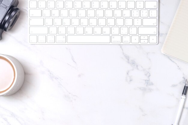 Marble study desk with keyboard, pen tablet, coffee and camera