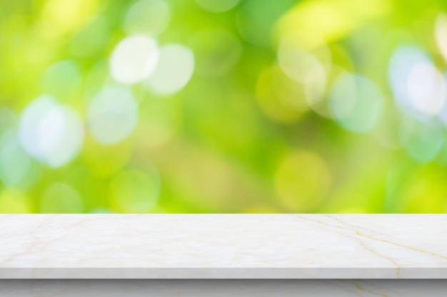 Marble table top with blur green leaf bokeh nature background