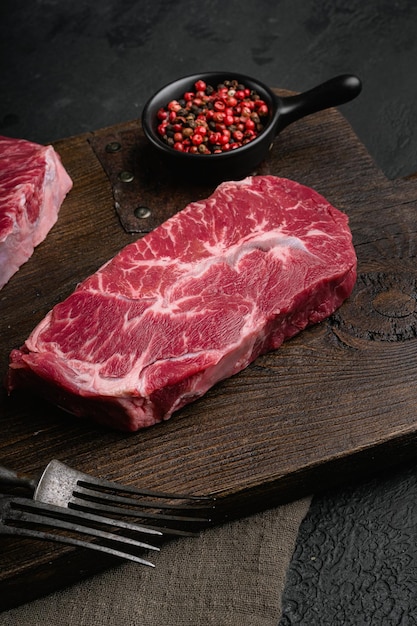 Marbled beef steak top blade meat steak on black dark stone\
table background