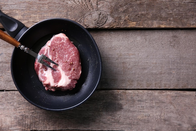 Marbled beef steak and wine bottle on wooden background