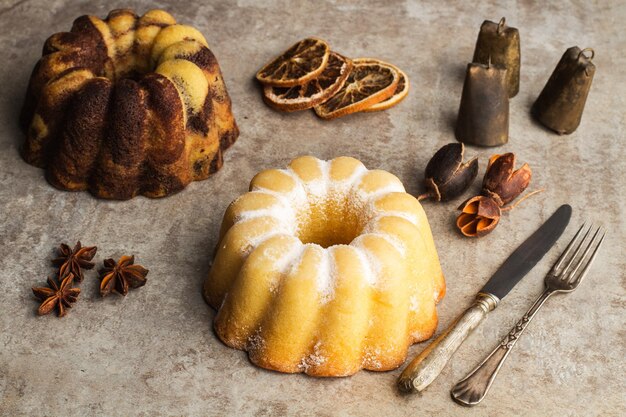 A marbled bundt cake and a lemon bundt cake on a marble table