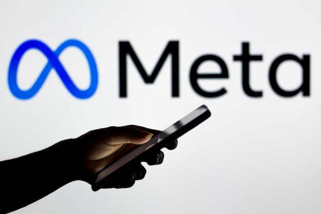 Foto 16 marzo 2022 brasile in questa illustrazione fotografica il logo meta platforms visto sullo sfondo di una silhouette di una donna che tiene un telefono cellulare