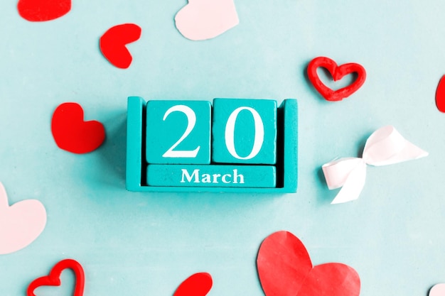 写真 3月20日 (日) 青いパステル色の背景に月日が描かれたカレンダー