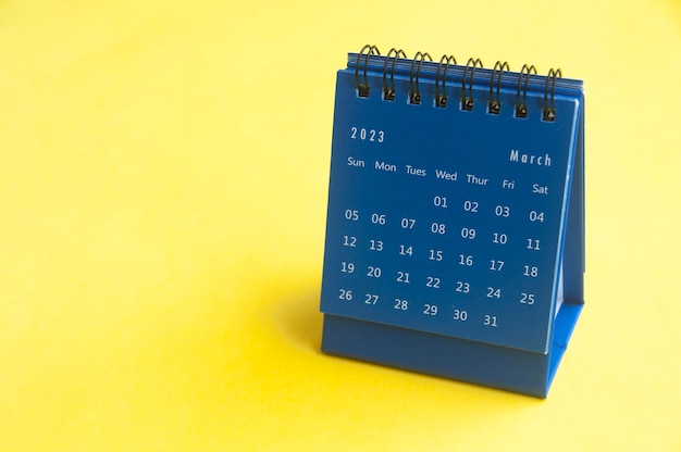 March 2023 blue desk calendar on yellow cover background with customizable space for text Copy space and calendar concept