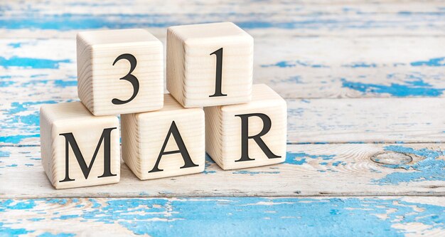 March 31st. Wooden cubes with date of 31 March on old blue wooden background.