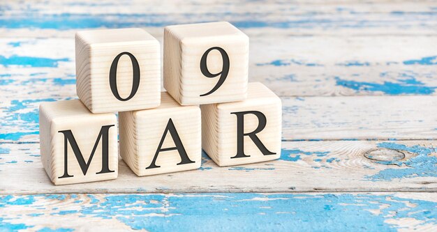 March 9th. wooden cubes with date of 9 march on old blue wooden background