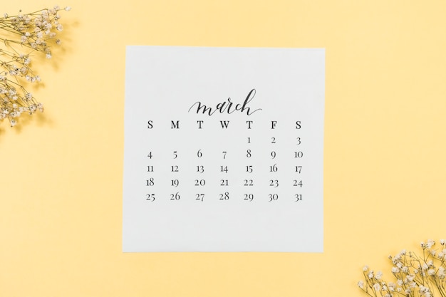 Мартовский календарь с цветочными ветками на столе