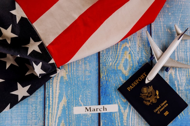 Foto bandiera americana degli stati uniti di mese di marzo con il passaporto americano e l'aereo dell'aereo di modello del passeggero