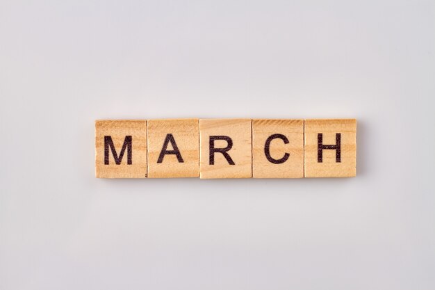 March word written on wood blocks. Isolated on white background.