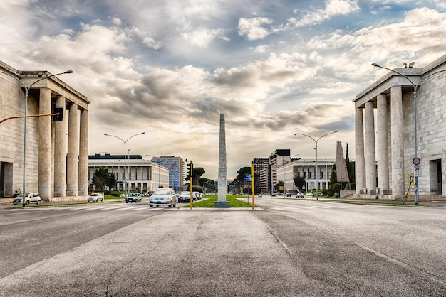 Marconi-obelisk in het eur-district tegen bewolkte lucht bij zonsondergang