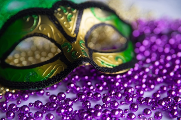 Mardi gras beads and mask close up.