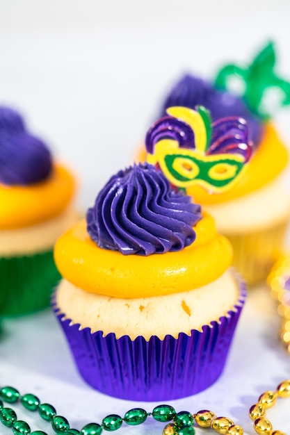 Mardi Gras vanilla cupcakes in foil cupcake cups and decorated with Italian buttercream frosting.