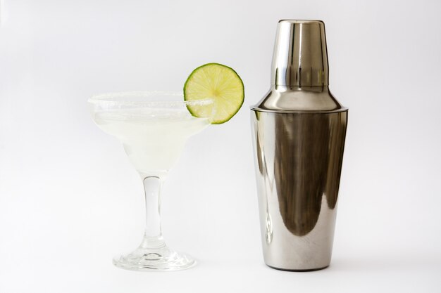 Margarita cocktail and shaker on white surface