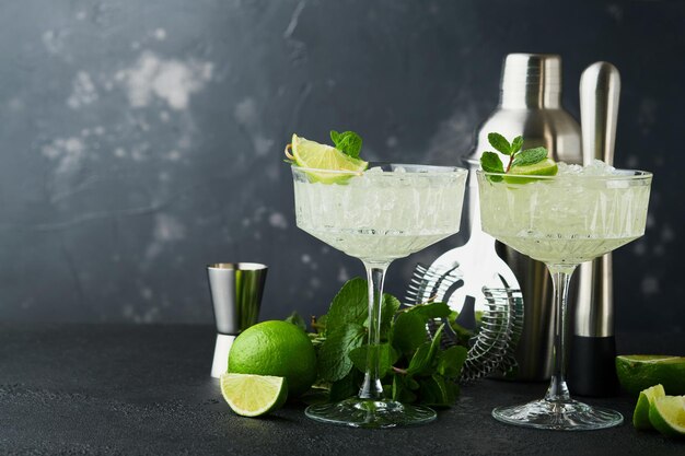 Margarita cocktail with lime tequila mint and ice on dark table with amazing backlight copy space Classic Margarita or Daiquiry Cocktail Bar card or counter concept Selective or soft focus